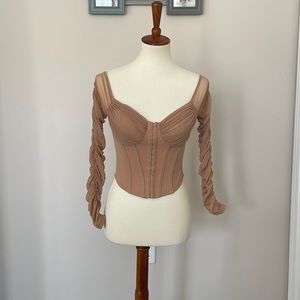 Nude corset crop top with sheer sleeves.